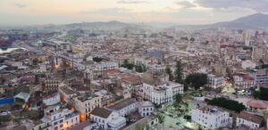 an aerial view of a city with mountains in the background